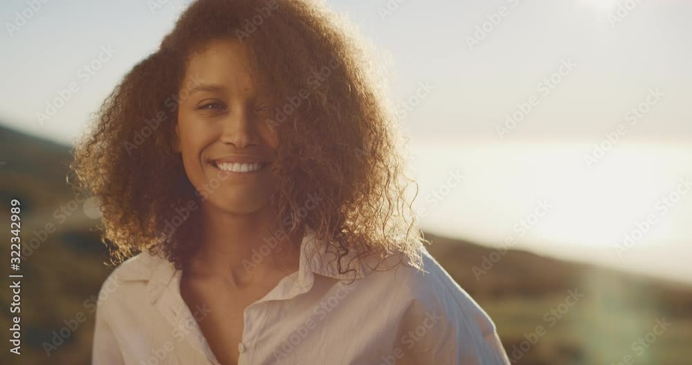 Portrait of a happy carefree african american woman smiling and enjoying herself at sunset, happy person at sunset