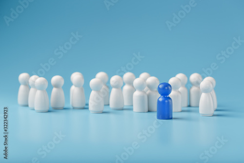 The leader in blue leads a group of white employees to victory  HR  Staff recruitment. The concept of leadership.