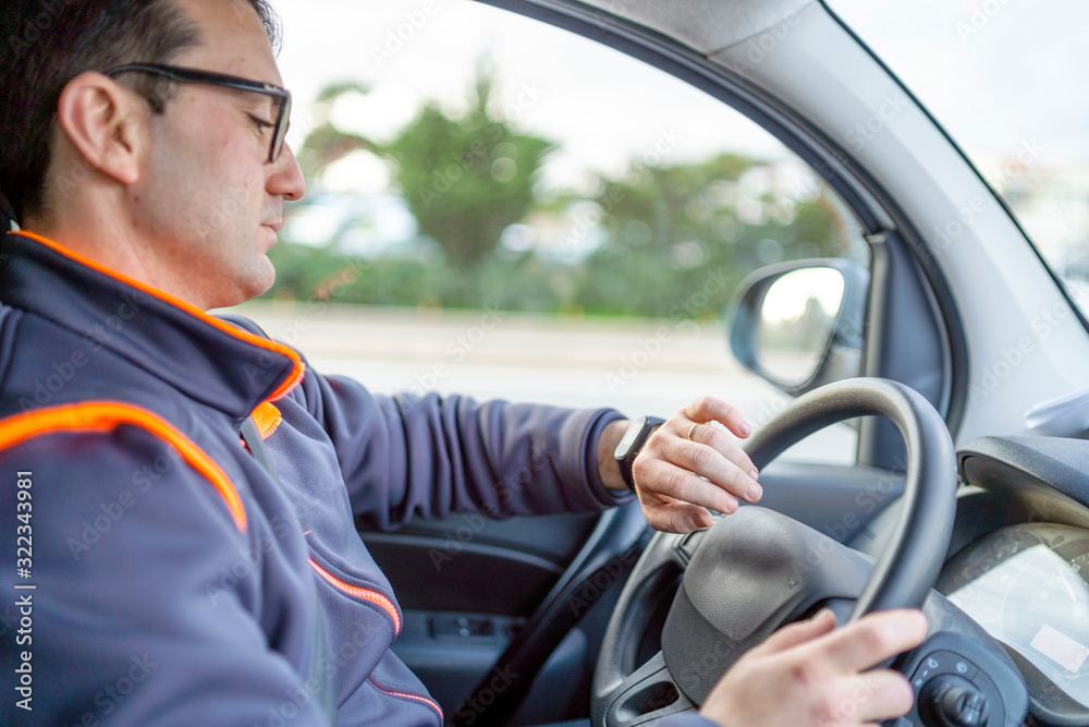 A man driving a car and looking on the watch A man driving a car and looking on the watch