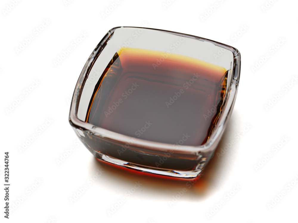 Soy sauce in a square glass cup. Isolated on white background with shadow