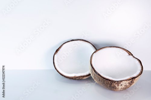 Bright coconut on white background with copy space. Two halves of appetizing coco neutral arrangement. 