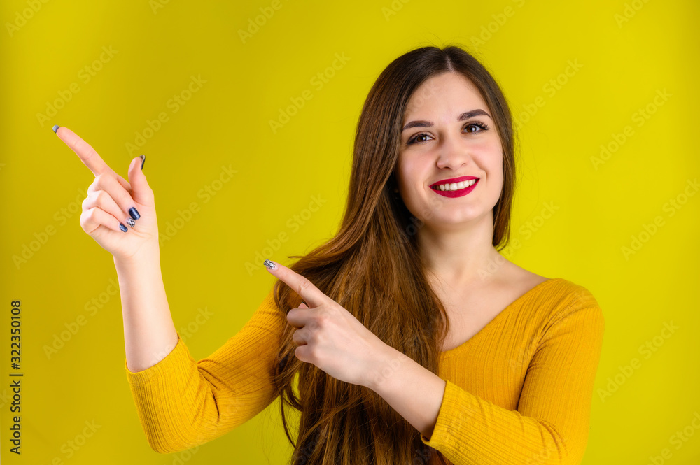 nice brunette girl with long hair with a smile in a yellow jacket rejoices on a yellow background, smiles and shows positive emotions nice brunette girl with long hair with a smile in a yellow jacket rejoices on a yellow background, smiles and shows positive emotions