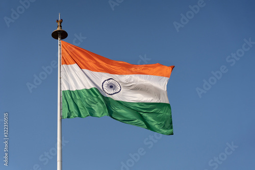Foto Waving Flag of India on a Flag Poll Against Blue Sky