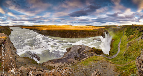 Panoramic view on Gullfoss waterfall on the Hvíta river, a popular tourist attraction and part of the Golden Circle Tourist Route in Southwest Iceland. Golden Waterfall. Travelling concept background.