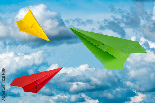 Three colorful paper planes flying in a sky