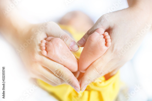 Baby feet in mother hands - hearth shape, Baby feet in mother hands. Mom and her Child. Happy Family concept. Beautiful conceptual image of Maternity.