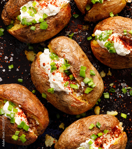 Baked potatoes filling with cream cheese and green onions seasoned with freshly ground black pepper and sea salt f photo