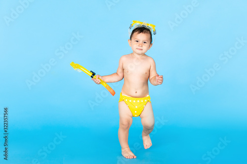 Holiday topic: child boy with snorkeling or diving equipment on a blue background. Adventure and rest concept