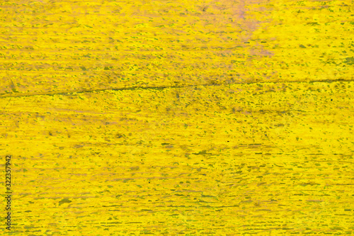 Wooden shabby fence painted in yellow. Texture, background.