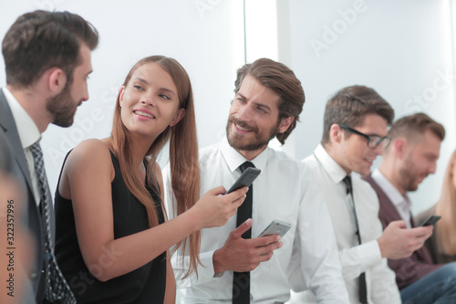 young employees of the company looking at the screens of their smartphones