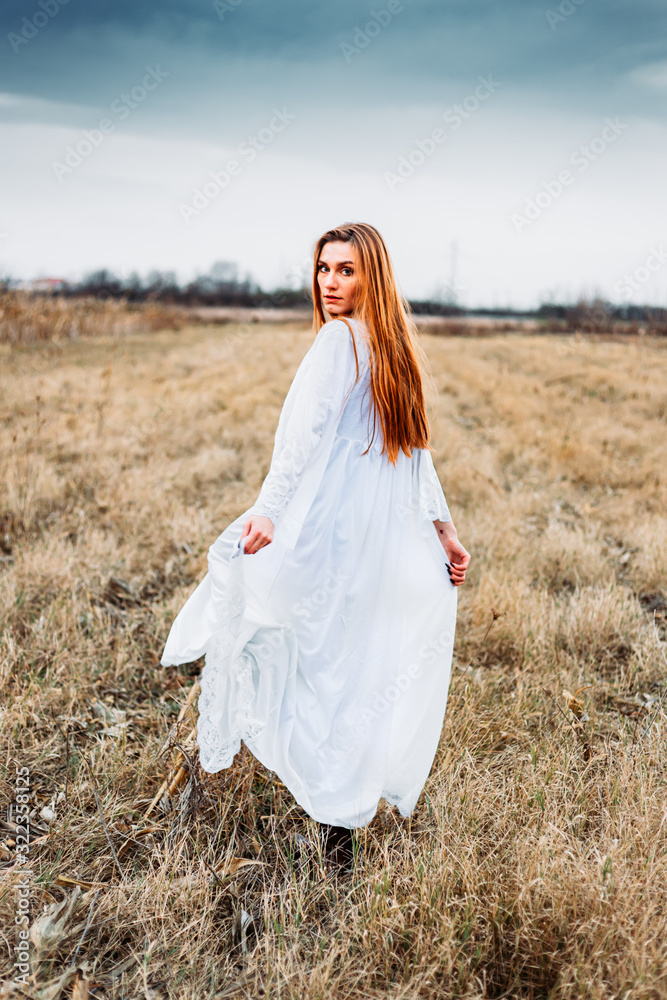 Beautiful girl in white nightgown, looking like a fairy on corn field.