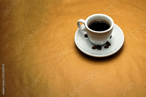 Coffee in a white cup and saucer on a beige background