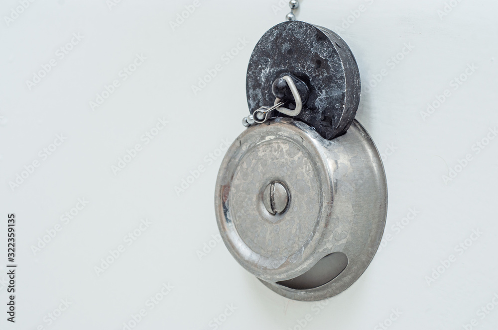 Obraz premium A stopper for a bath with a leash lies in its place in the groove. Dirty in white stains.