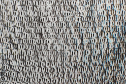 Grey pleated silk fabric background.