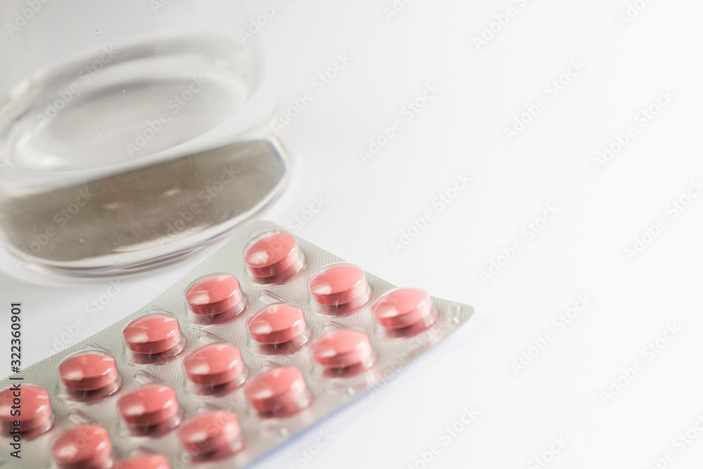 Pills capsules medicine and glass of water on white background Pills capsules medicine and glass of water on white background