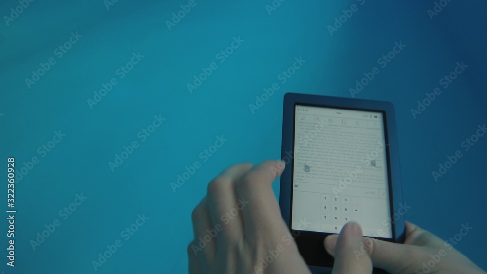 Man reads an electronic book underwater. This is a special waterproof electronic device. You can read the text and show signs directly underwater.