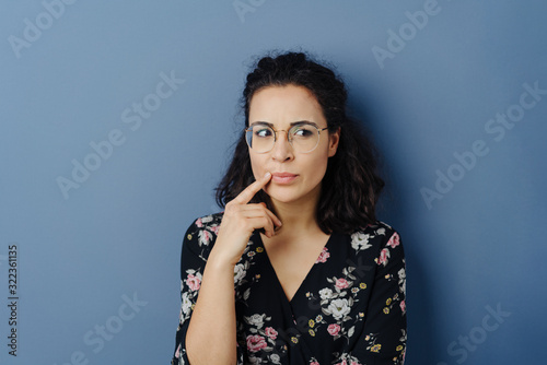 Canvas Print Thoughtful young woman glancing aside