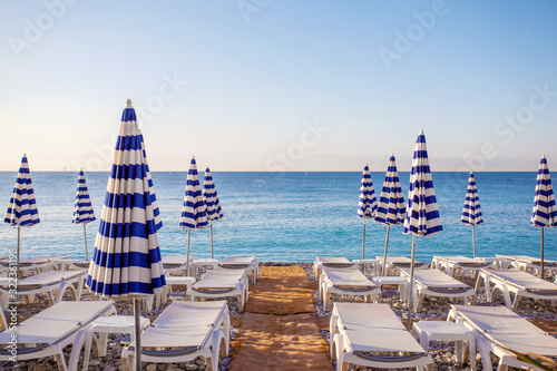 View of the blue striped umbrellas on the beach in Nice, Cote d'Azur, Southern France photo