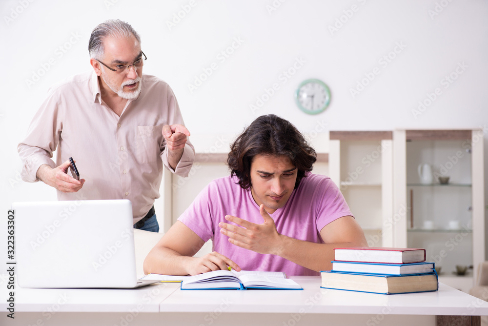 Fototapeta premium Old father helping his son in exam preparation
