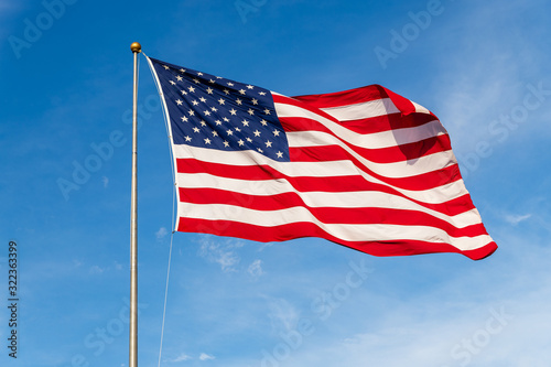 American Flag waving in the wind, with beautiful red white and blue colors.