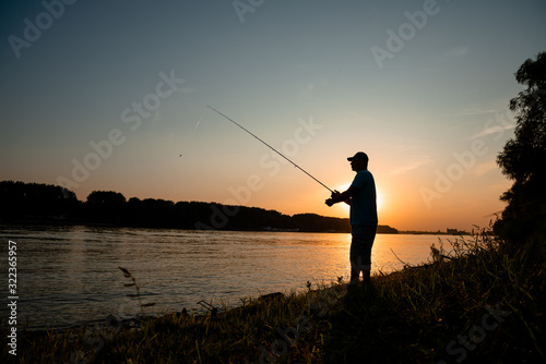 Men fishing on the river on sunset