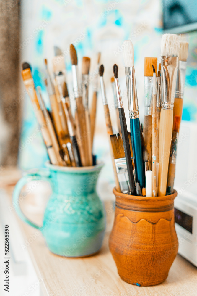 Tools and equipment for the artist. Palette and brushes close-up. The process of drawing and creativity. The picture is in blue. Tools and equipment for the artist. Palette and brushes close-up. The process of drawing and creativity. The picture is in blue.