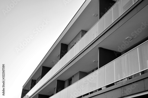 Detail of modern residential flat apartment building exterior. Fragment of new luxury house and home complex. Black and white.