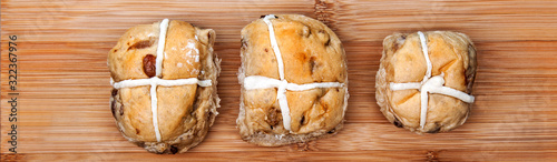 Hot cross buns on plain, rustic, wooden background - Easter banner / design / header / panorama. photo