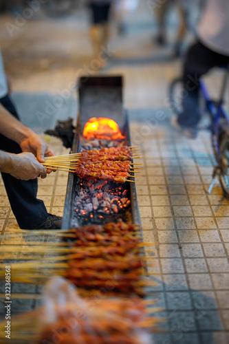 Man preparing skewers in street of Shanghai.