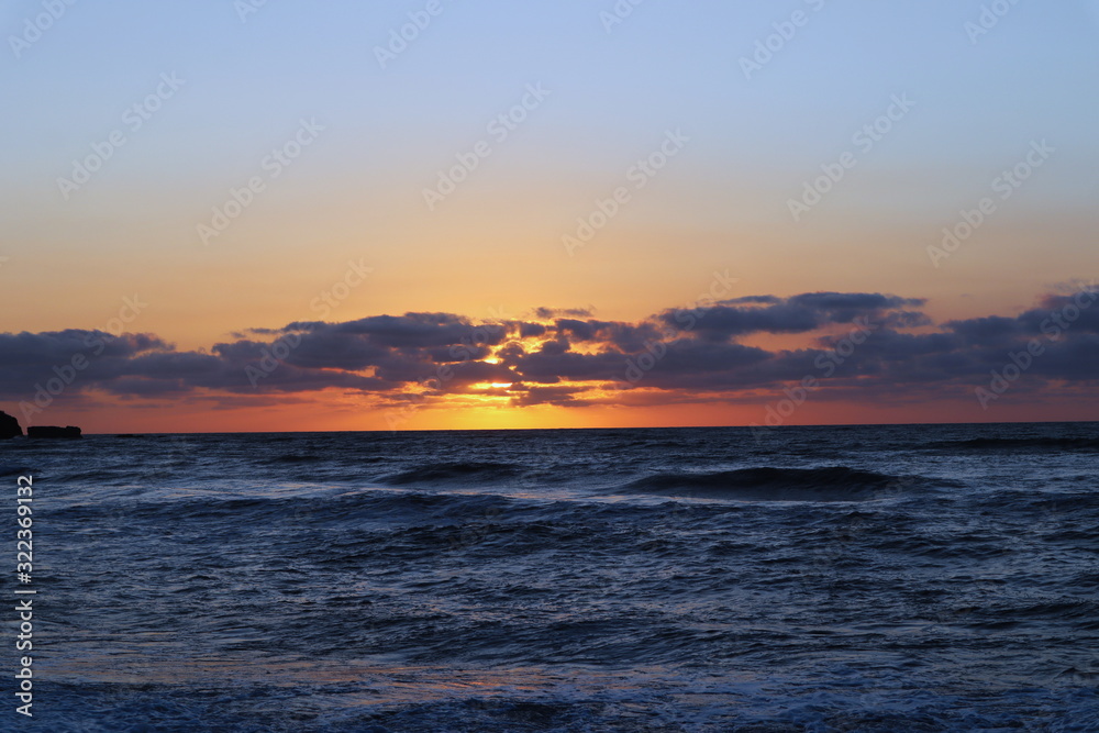 Beautiful sunset with clouds over rough seas 