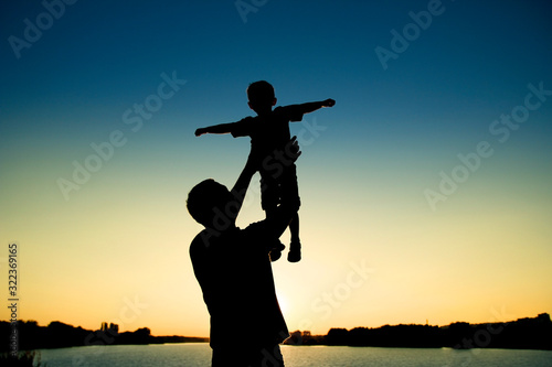 silhouette of father and son on sunset