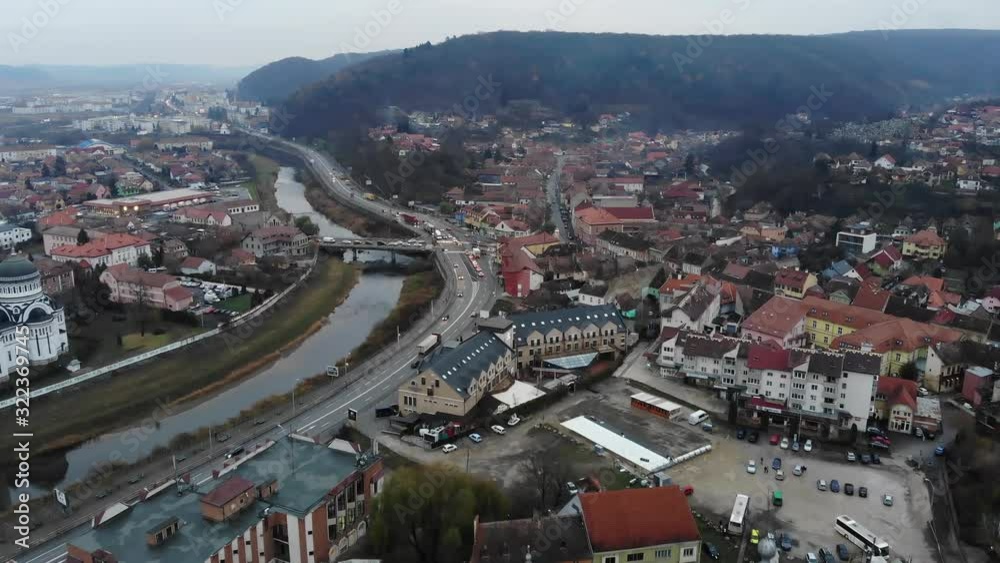Drone flying over medieval city of Sighisoara, Romania with view of the mountains and the cityscape Drone flying over medieval city of Sighisoara, Romania with view of the mountains and the cityscape