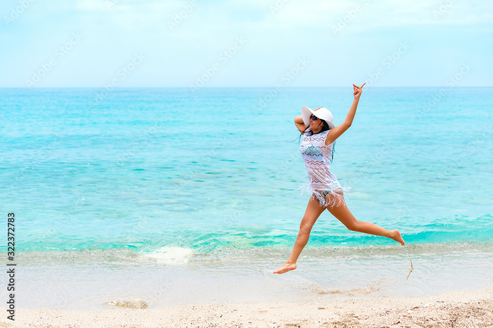 Happy women in white is jumping by the water Happy women in white is jumping by the water