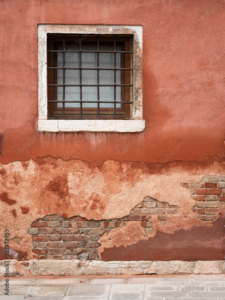 Fototapeta premium Window in an old brick wall near water in Venice