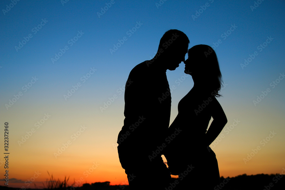 silhouette of a pregnant couple in love