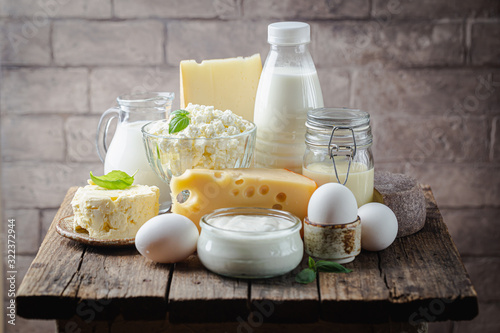 Fresh dairy products, milk, cottage cheese, eggs, yogurt, sour cream and butter on wooden table photo