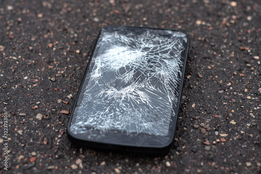 Phone with broken screen on asphalt. Someone dropped device. Phone with broken screen on asphalt. Someone dropped device.