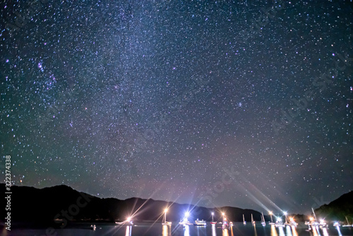 Starry sky with milky way above boat anchored in a bay of Abel Tasman National Park, New Zealand