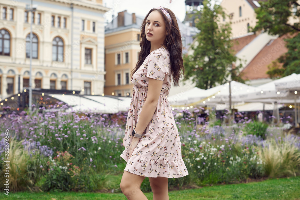 Young beautiful bright girl in a summer dress laughing in the city park Young beautiful bright girl in a summer dress laughing in the city park