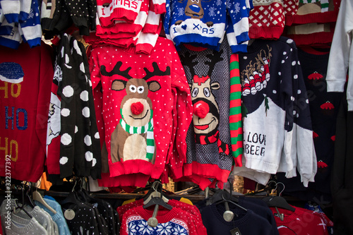 A temporary seasonal display of ugly Christmas sweaters at a retail store .