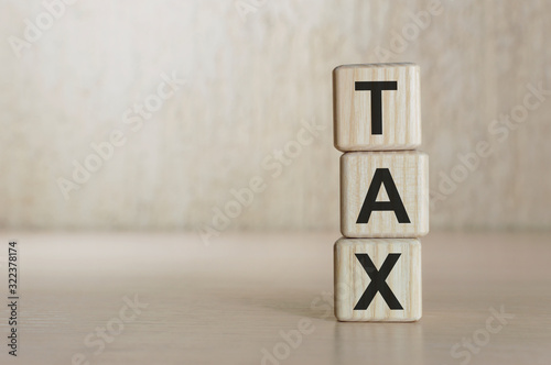 Tax word written on wood block. Tax text on wooden table for your desing, concept.