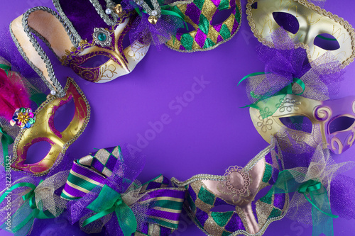 A group of Mardi Gras mask making a frame with copy space on a purple background