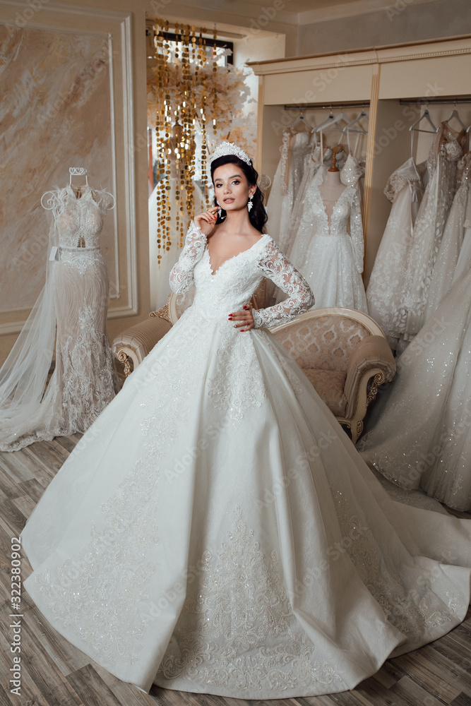 Bride girl. Woman. Wedding fashion and beauty salon. Fashion model or princess at prom. Sexy girl in white dress with stylish hair. Full length photo of bride in wedding shop Bride girl. Woman. Wedding fashion and beauty salon. Fashion model or princess at prom. Sexy girl in white dress with stylish hair. Full length photo of bride in wedding shop