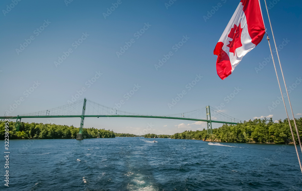 Naklejka premium Boating under Canadian flag through the waterway of Thousand islands