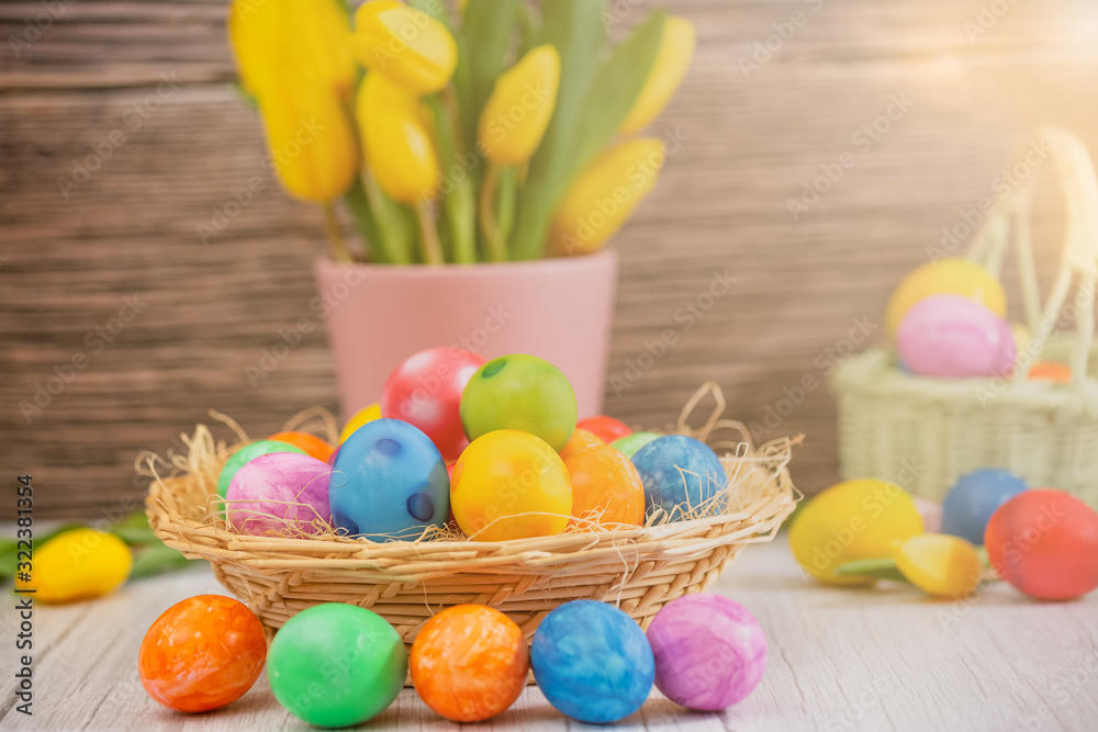 Beautiful group Easter eggs in the spring of easter day, red eggs, blue, purple and yellow in Wooden basket with tulips on the wood table background Beautiful group Easter eggs in the spring of easter day, red eggs, blue, purple and yellow in Wooden basket with tulips on the wood table background