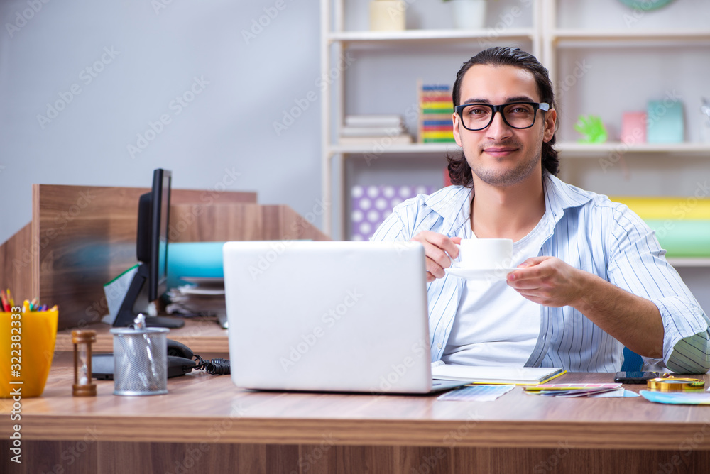 Young male designer working in the office Young male designer working in the office