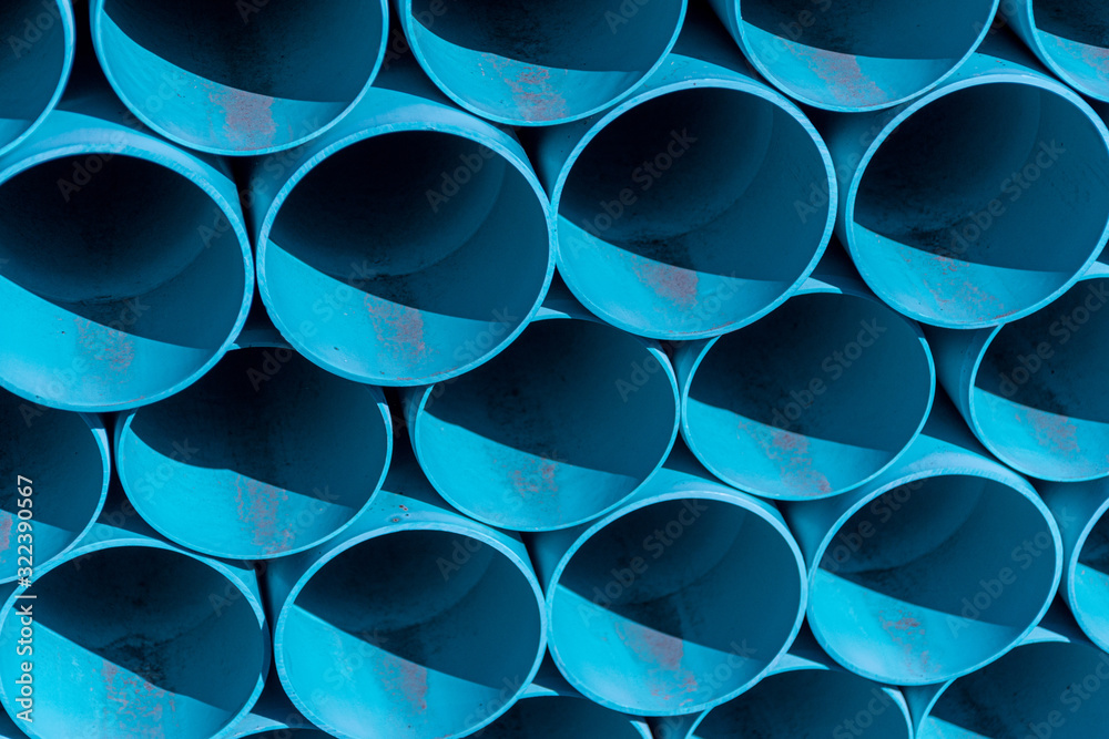 large blue PVC piping horizontally stacked high at a construction site in Upstate NY large blue PVC piping horizontally stacked high at a construction site in Upstate NY