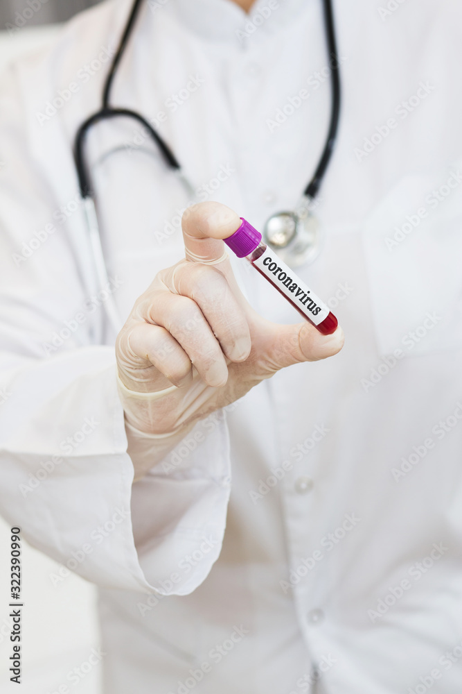 a doctor in a white coat, with a phonendoscope around her neck and gloves, holds a positive blood test for coronavirus COVID-2019. test tube with virus analysis a doctor in a white coat, with a phonendoscope around her neck and gloves, holds a positive blood test for coronavirus COVID-2019. test tube with virus analysis
