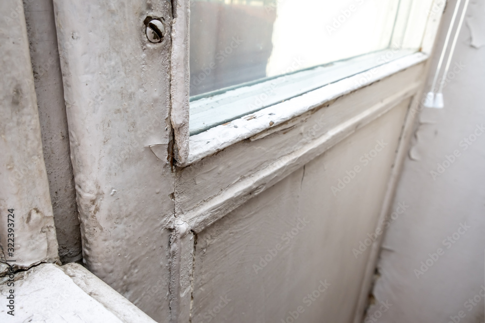 Obraz premium Old wooden window with peeling paint and durt needed to be repaired or replaced
