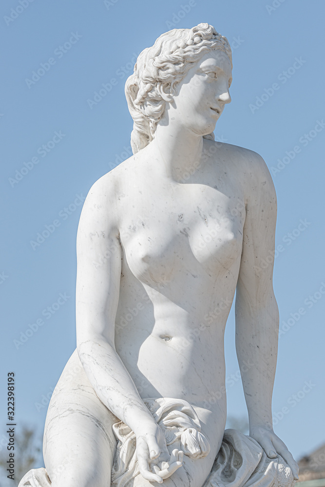 Old statue of a sensual naked Renaissance Era woman in the park of Potsdam, Germany, details, closeup